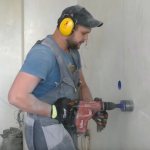 drilling a hole for socket boxes in a concrete wall